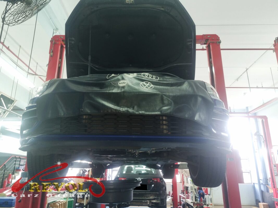 The Golf up on the two-post lift, front covered, in for the coolant leak and the low-coolant warning.