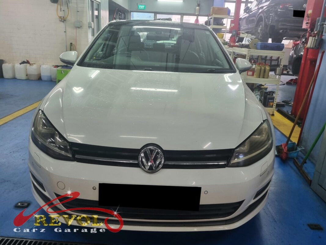 Volkswagen Golf on the workshop lift with the engine supported on a jack for mount replacement.