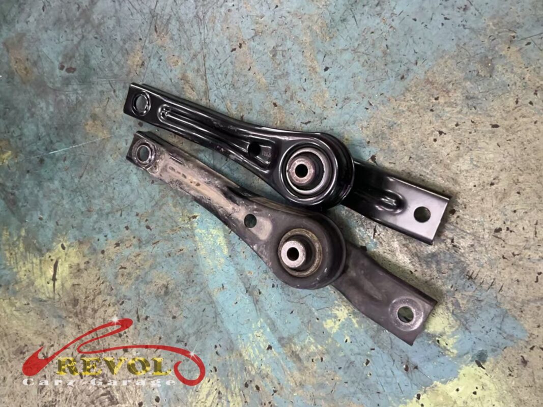 The new VAG-spec lower torque link (top) beside the worn original (bottom).