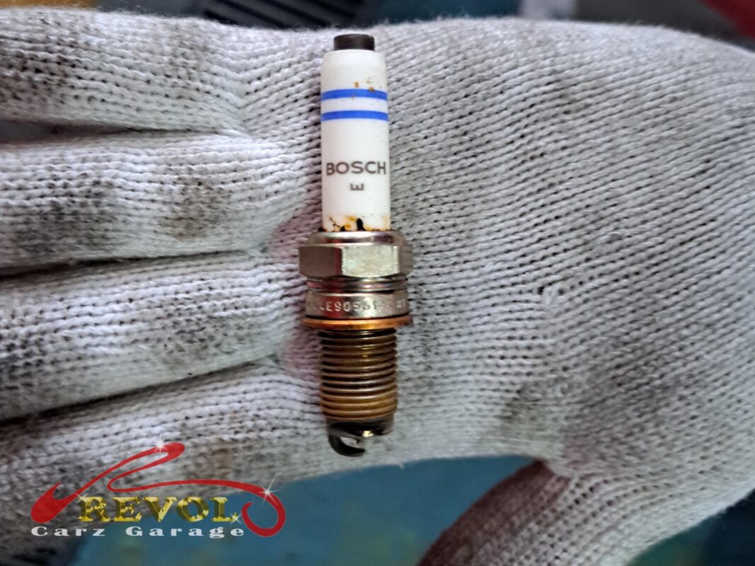 One of the old Bosch plugs out, the tip fouled and the threads stained.