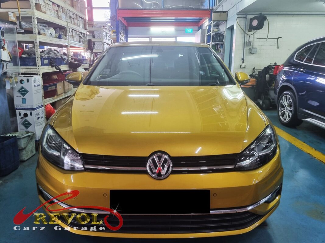 Volkswagen Golf on the workshop lift with the front-right wheel off for bearing replacement.