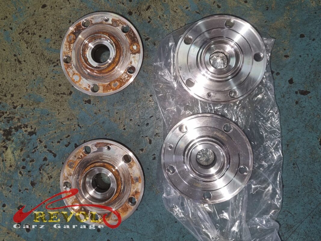 The old hub bearing assemblies (left, rusted) beside the new VAG-spec replacements (right).