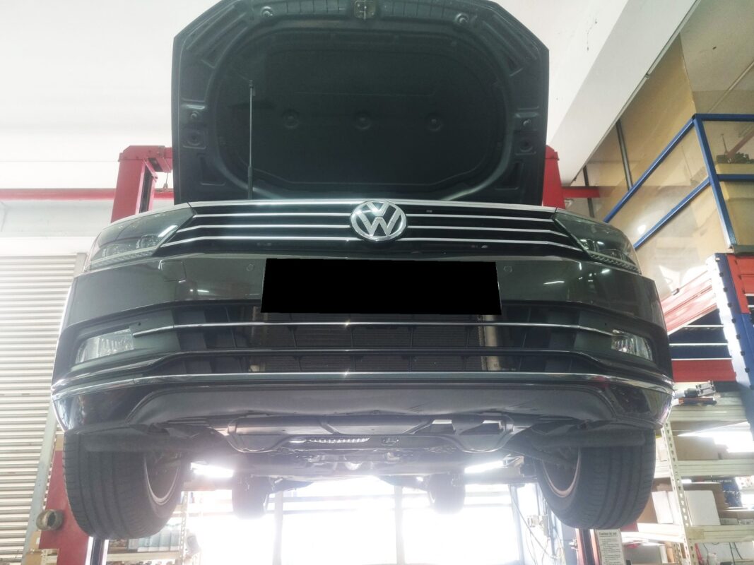 The Passat up on the two-post lift, bonnet open, in for the oil leak.