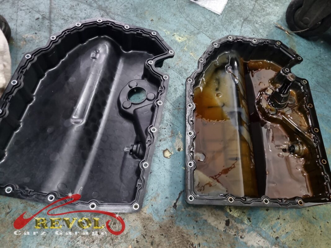 The old sump pan (right, sludge inside) beside the new VAG-spec replacement (left).