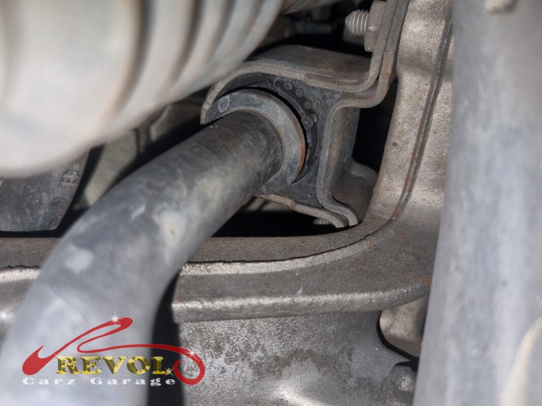 One of the anti-roll bar bushes in its clamp, the rubber tired and the bar surface-rusted.
