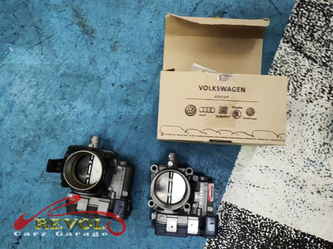 The old throttle body (left, carbon on the butterfly) beside the new VAG-spec replacement (right), genuine VW part.