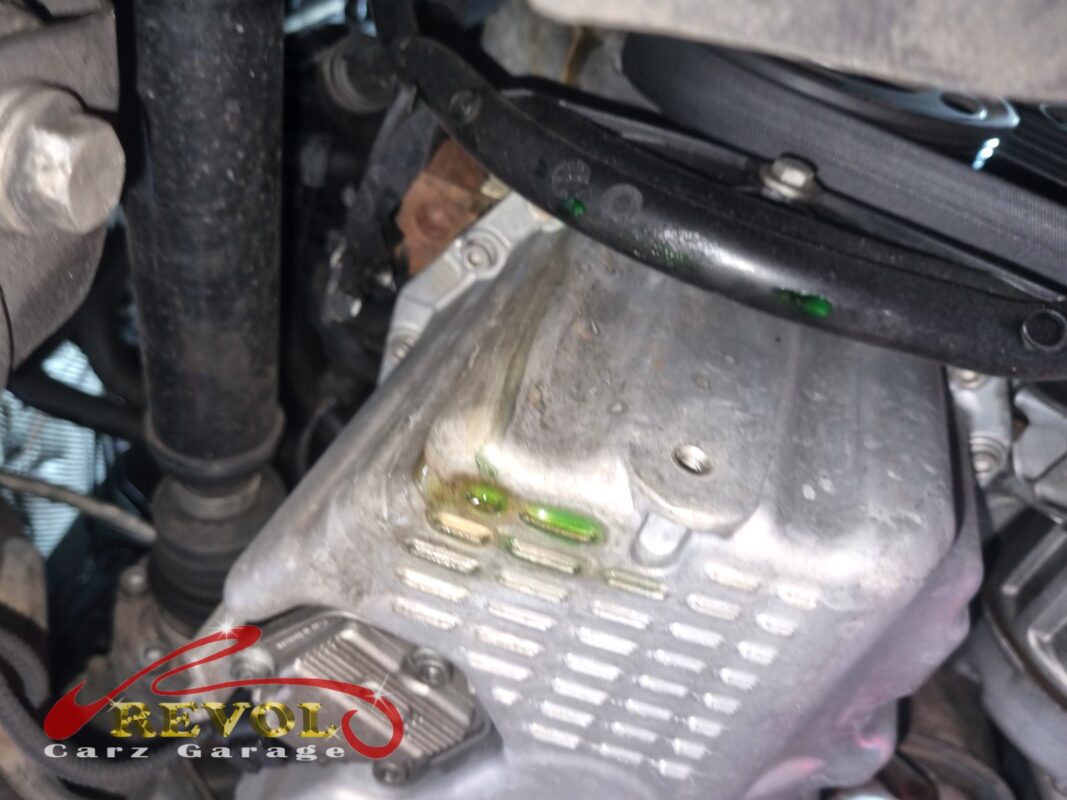 Bright green leak-detection dye in the coolant, marking the trail down from the water pump.