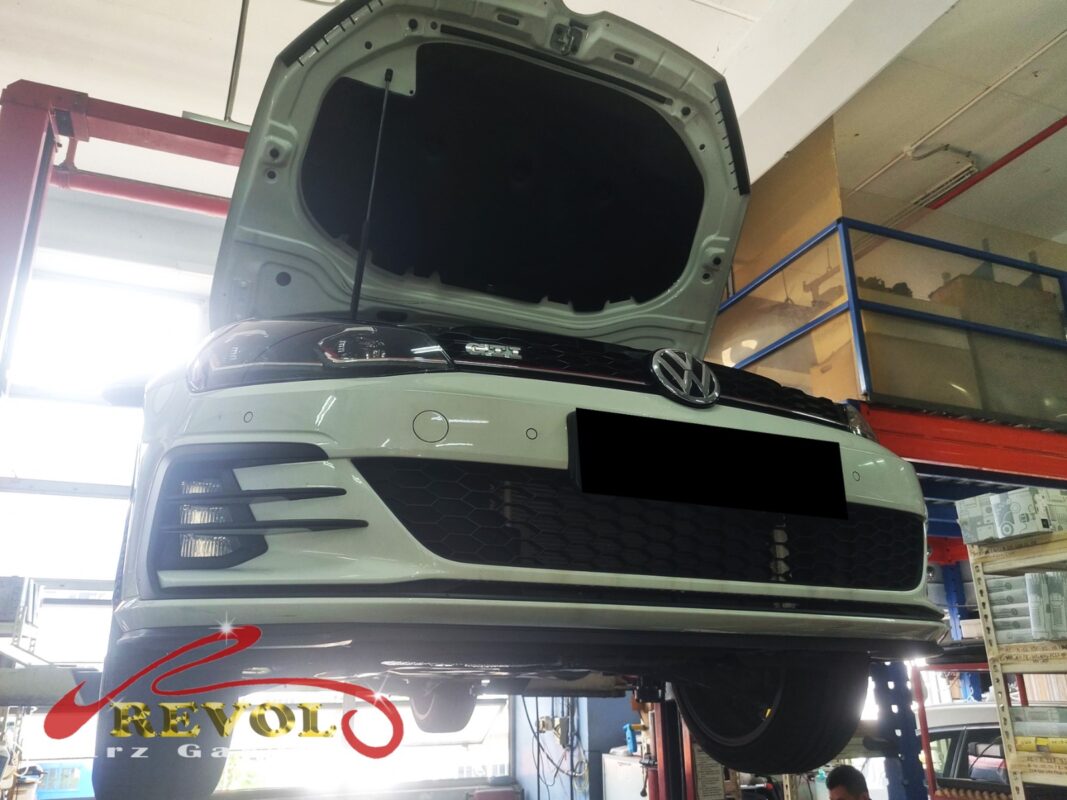 The Golf up on the two-post lift, bonnet open, in for the coolant leak.