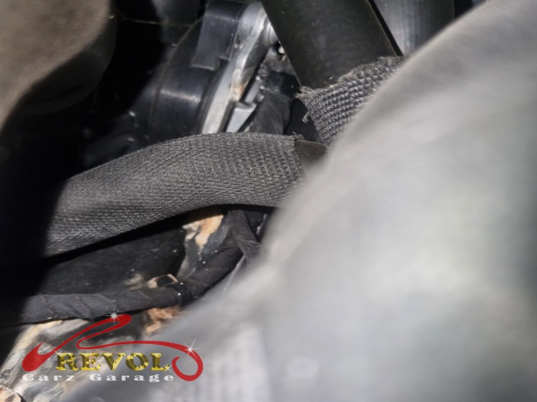 Dried coolant residue around the heat-wrapped coolant pipes near the pump, the leak that brought it in.