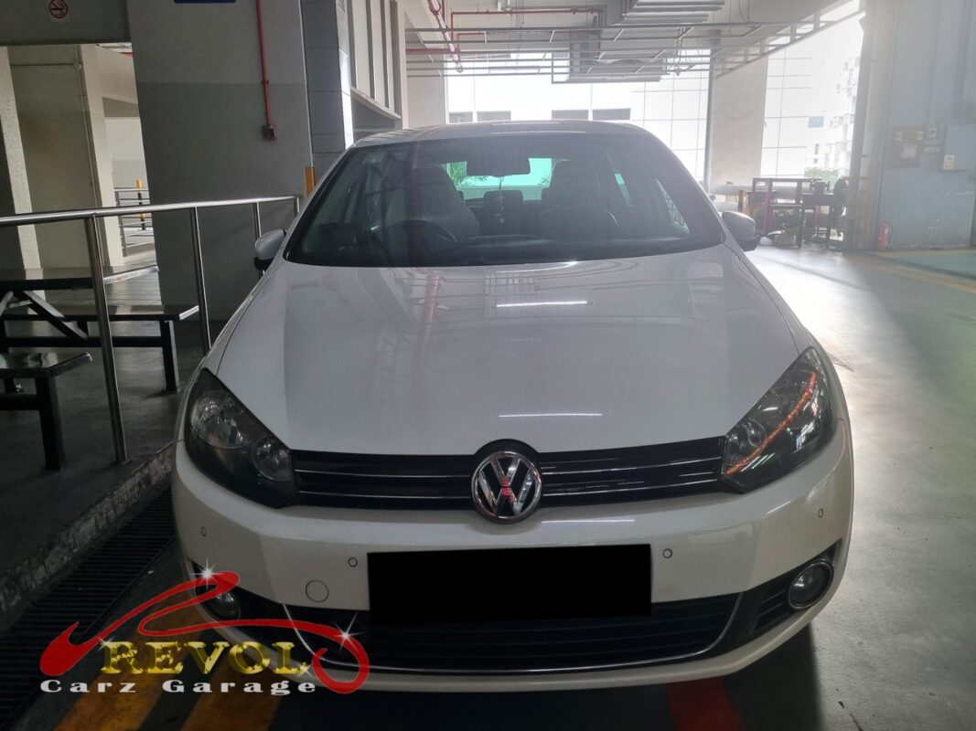 Volkswagen Golf on the workshop lift with the front wheel off for bearing diagnosis.