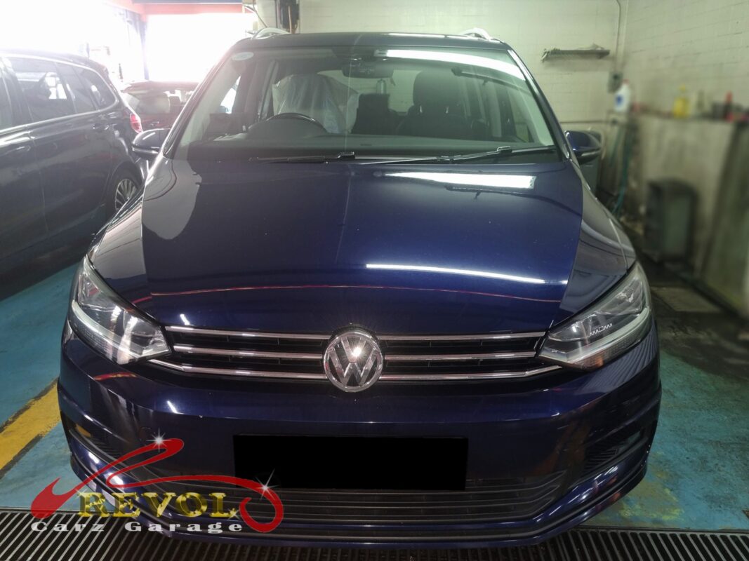 Volkswagen Touran on the lift with the front subframe partially dropped for bushing replacement.