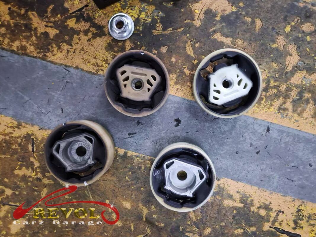 The worn subframe bushings beside the new VAG-spec replacements.