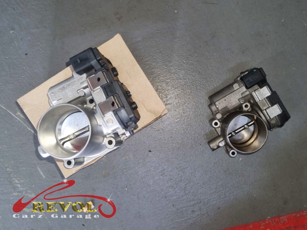 The new VAG-spec throttle body (left) beside the old one (right, carbon on the butterfly).