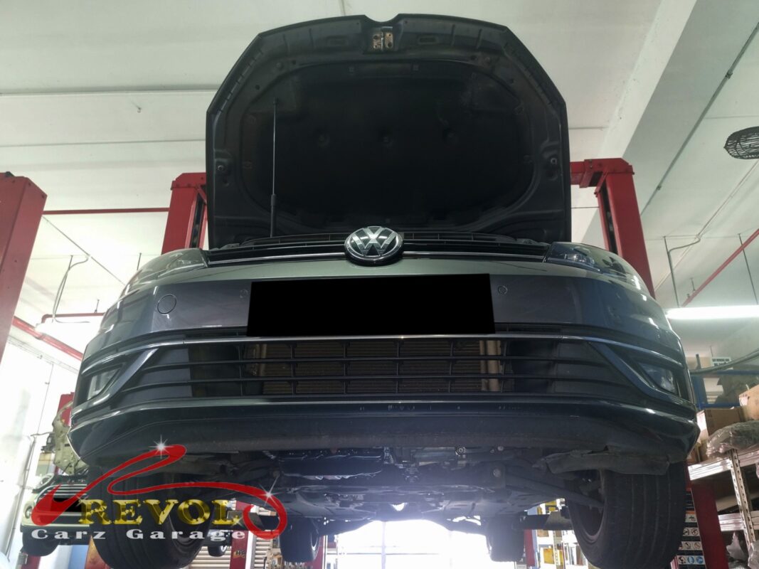 The Golf up on the two-post lift, bonnet open, in for the oil leak.