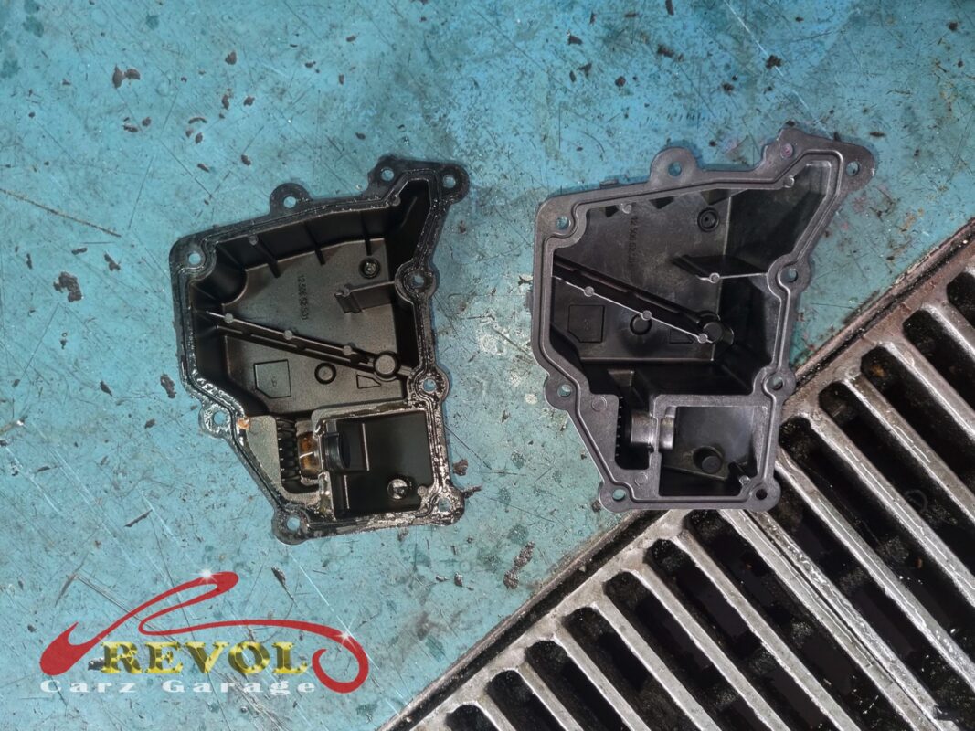 The old oil separator cover (right, oil-stained) beside the new VAG-spec replacement (left), with a fresh diaphragm and seal.