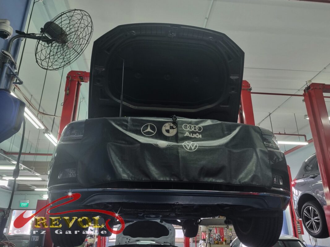 The Passat up on the two-post lift, front covered, in for the high temperature.