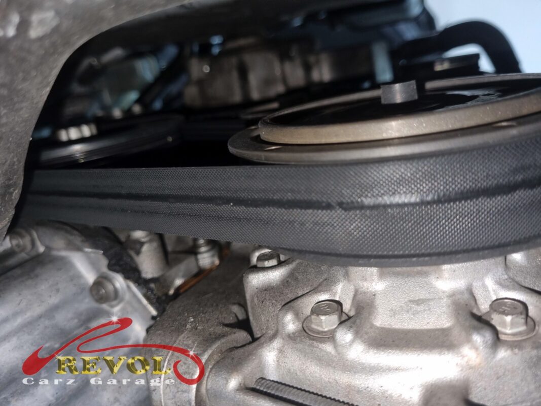 The accessory belt routed around the pulleys, the worn belt before it came off.