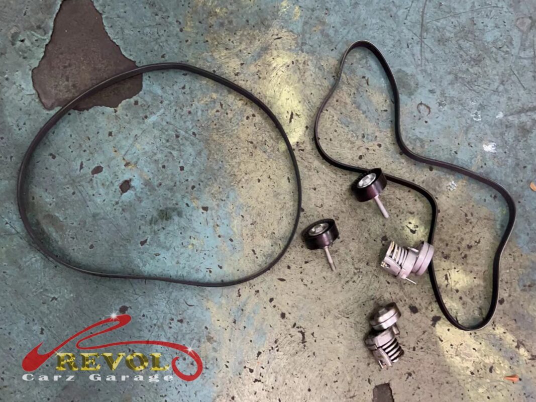 The old accessory belt (left) beside the new VAG-spec belt, with the new tensioner and idler pulley (right).