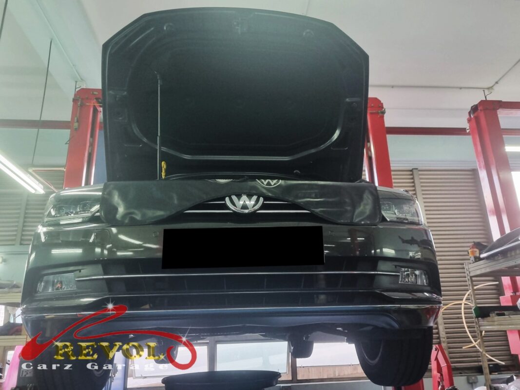 The Passat up on the two-post lift, front covered, in for the oil leak.