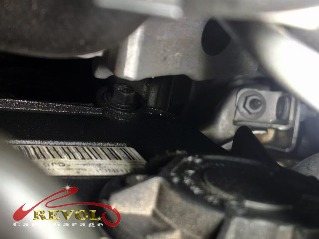 The timing cover area on the front of the engine, oily residue around the seal, before the cover came off.