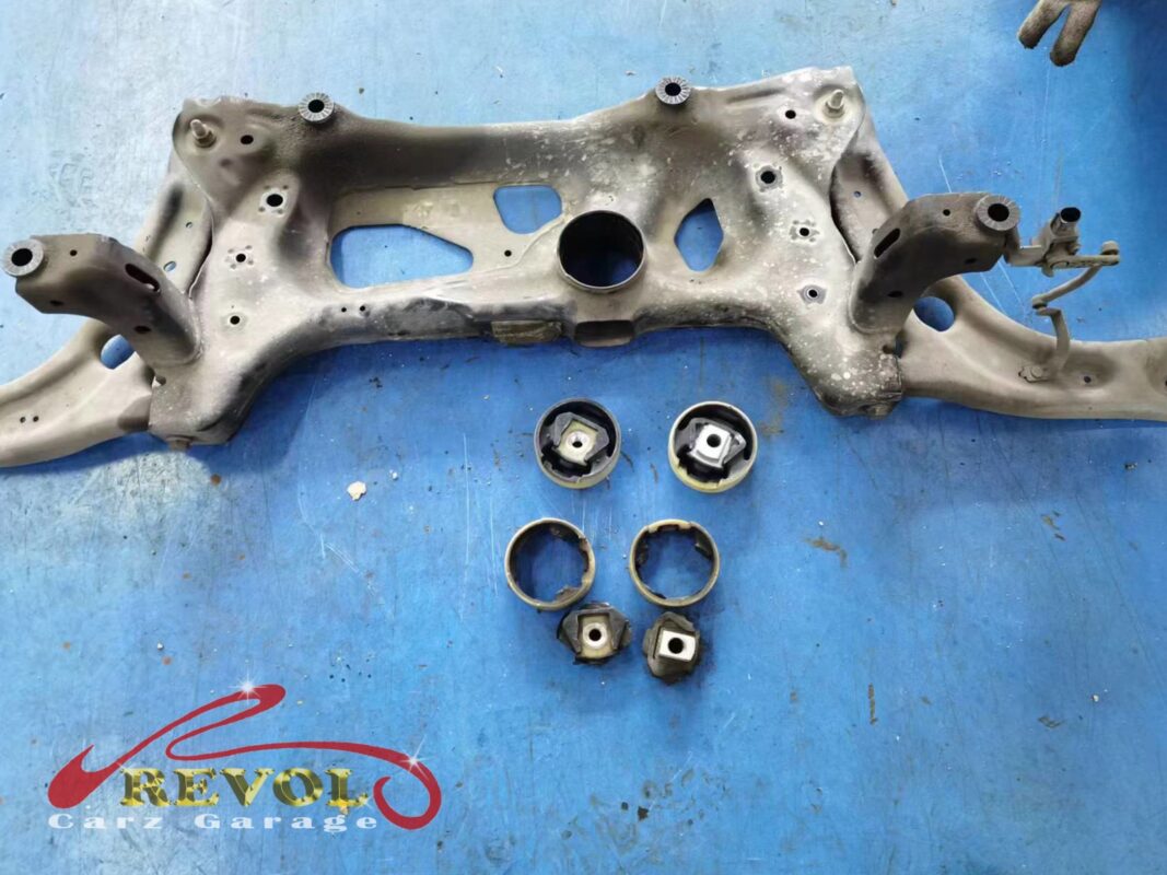 The front subframe out of the car, with the worn bushings (below) beside the new VAG-spec replacements.