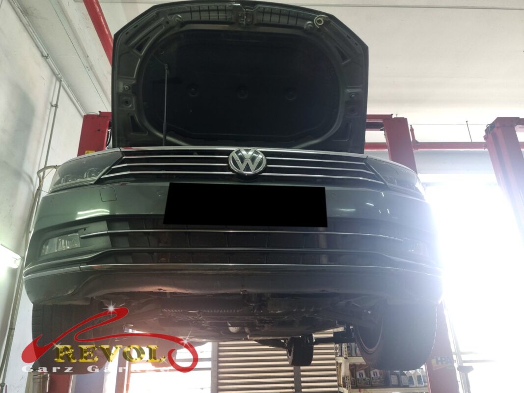 The Passat up on the two-post lift, bonnet open, in for the belt squeal.