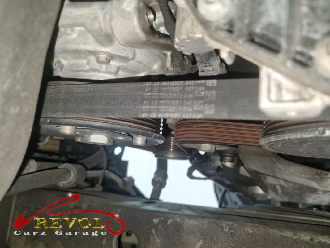 The accessory belt routed around the pulleys, the worn belt before it came off.