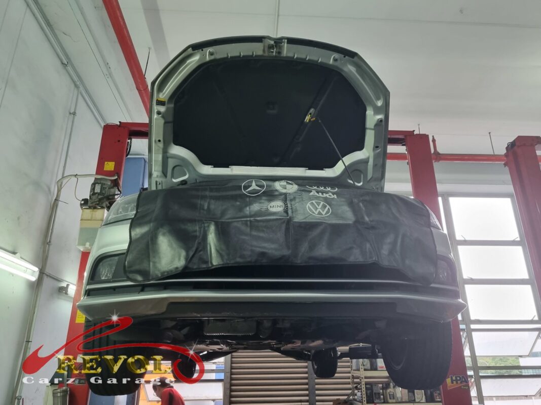 The Jetta up on the two-post lift, front covered, in for the oil leak.
