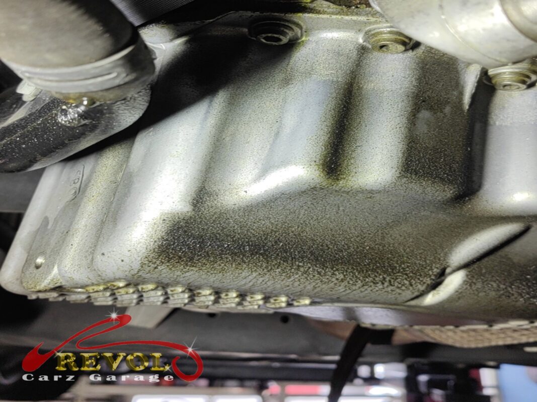 Looking up at the oil pan, the whole underside misted with oil from the weeping gasket.