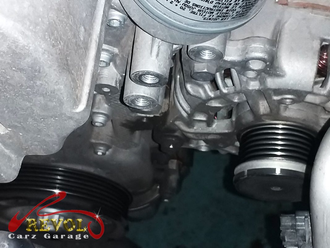 The old coolant pump and thermostat module removed showing the rough bearing.
