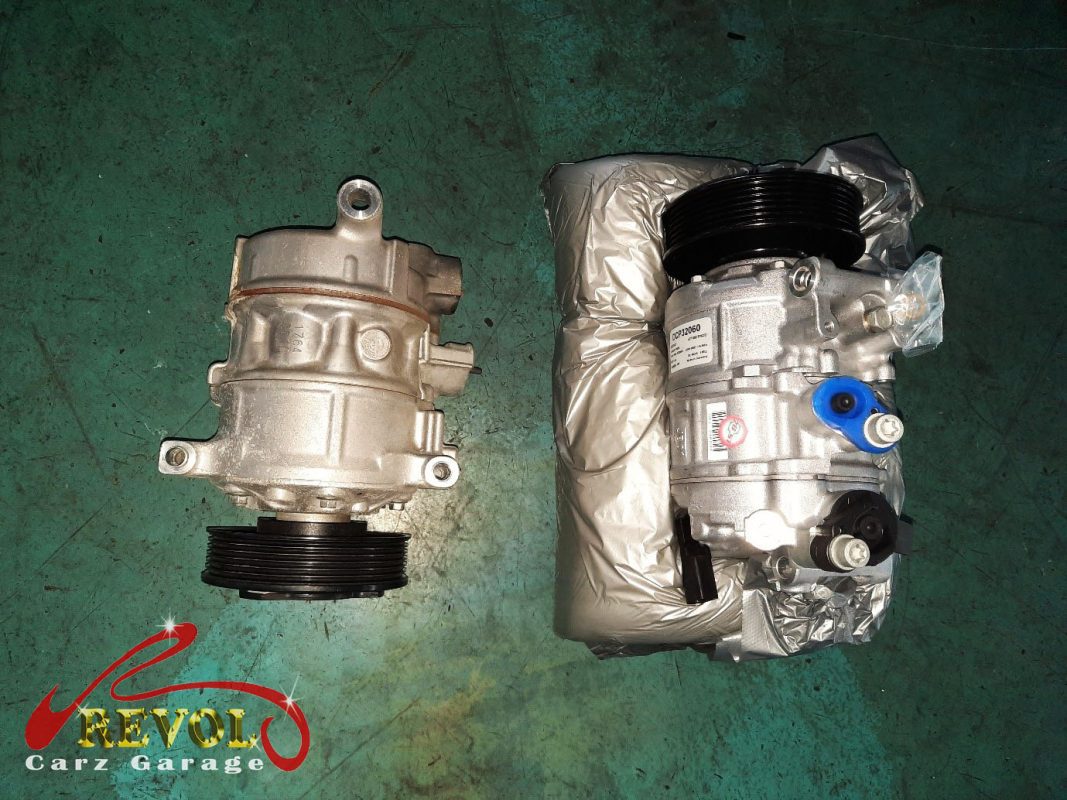 The failed aircon compressor removed alongside the new compressor and receiver-drier.