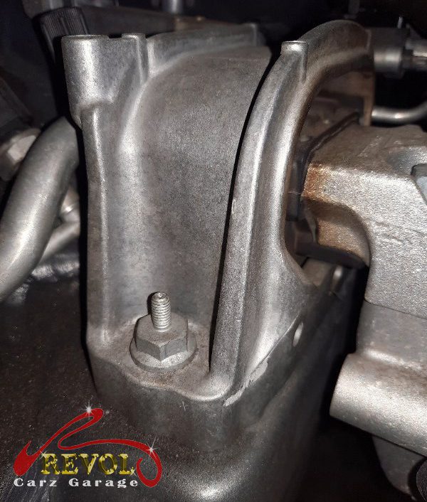 The worn engine mount with cracked and sunken rubber on the Volkswagen Touran.