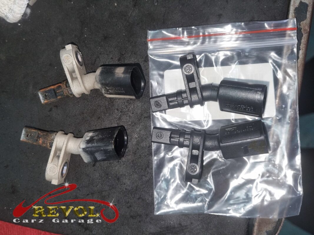 The two old front ABS sensors (left) beside the new VAG-spec replacements (right, bagged).
