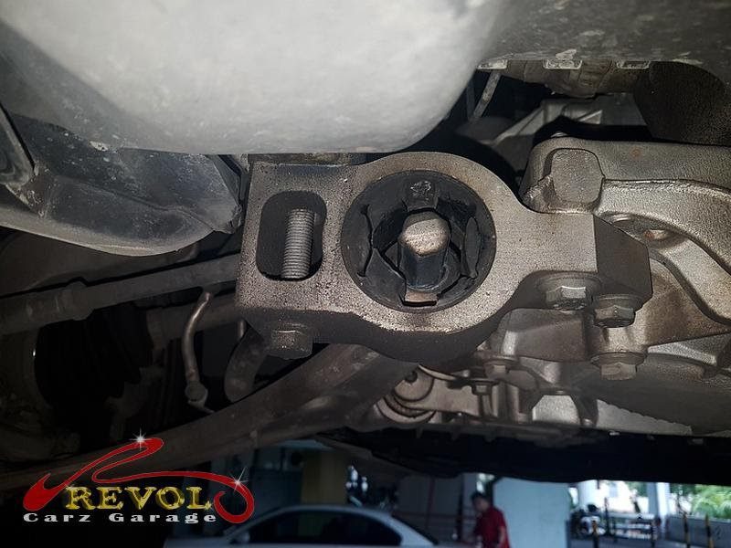 The worn front control arm bush with cracked, separating rubber.