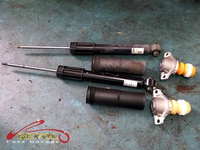 The old rear shock absorber showing seepage and soft damping.