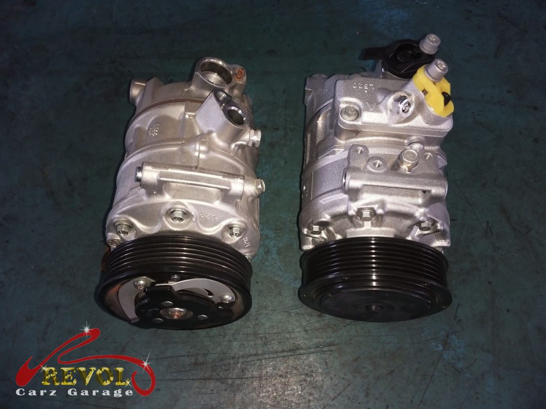 The old failed compressor removed alongside the new compressor and receiver-drier.