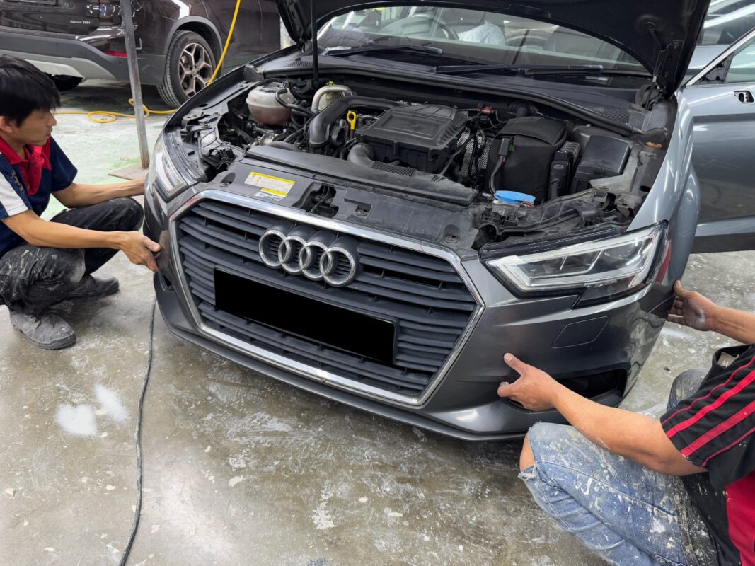 Car parts being dismantled from the Audi A3 in preparation for spraying.