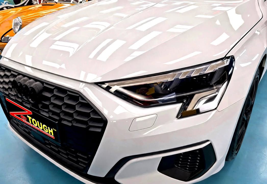 Front grille, headlight and white bonnet of the Audi A3.