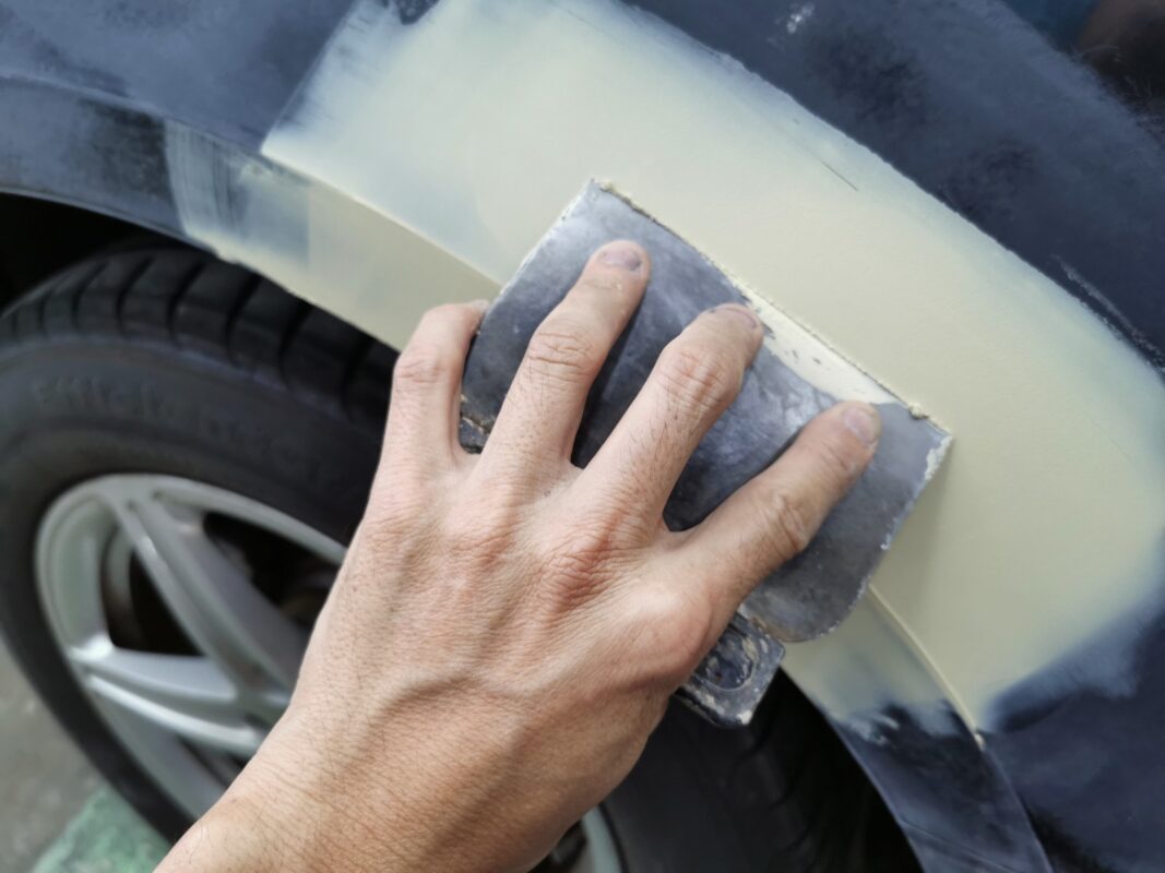 A panel on the Audi A4 being wet-sanded on Day 3 to level the surface.