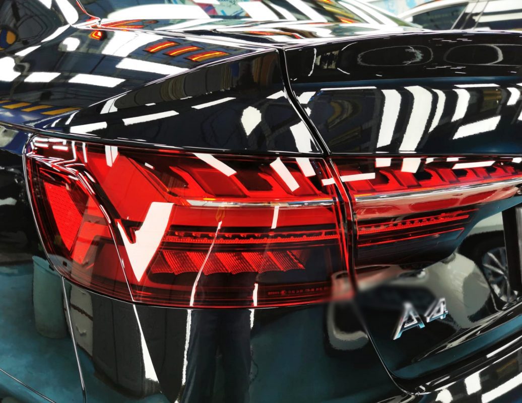 The coated bonnet of the Audi A4 under workshop lighting.