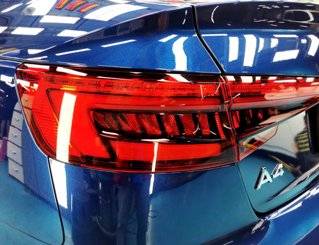 The coated bonnet of the Audi A4 under workshop lighting.