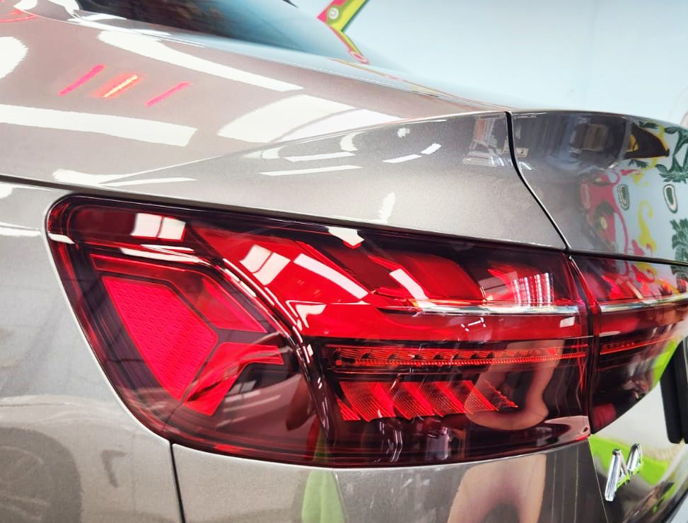 The coated bonnet of the Audi A4 under workshop lighting.