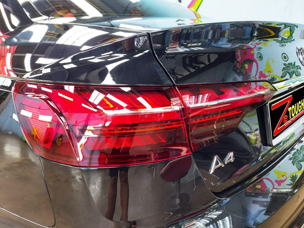 The coated bonnet of the Audi A4 under workshop lighting.