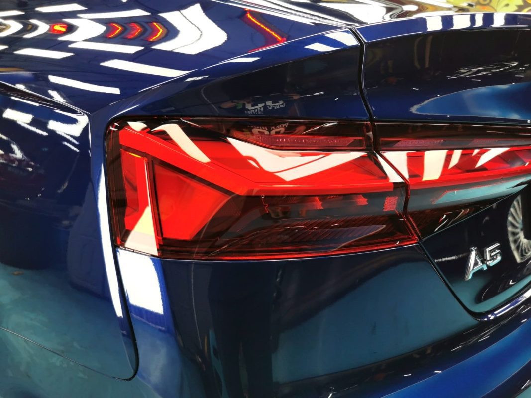 The coated bonnet of the Audi A5 under workshop lighting.