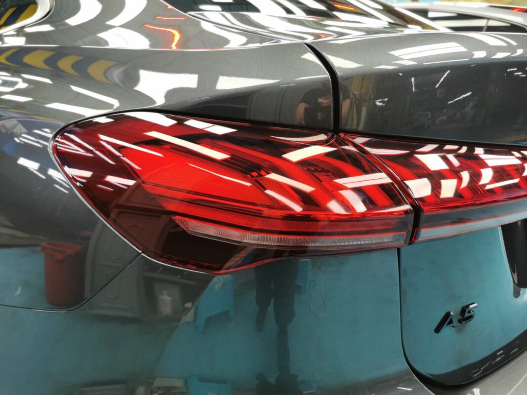 The coated bonnet of the Audi A5 under workshop lighting.