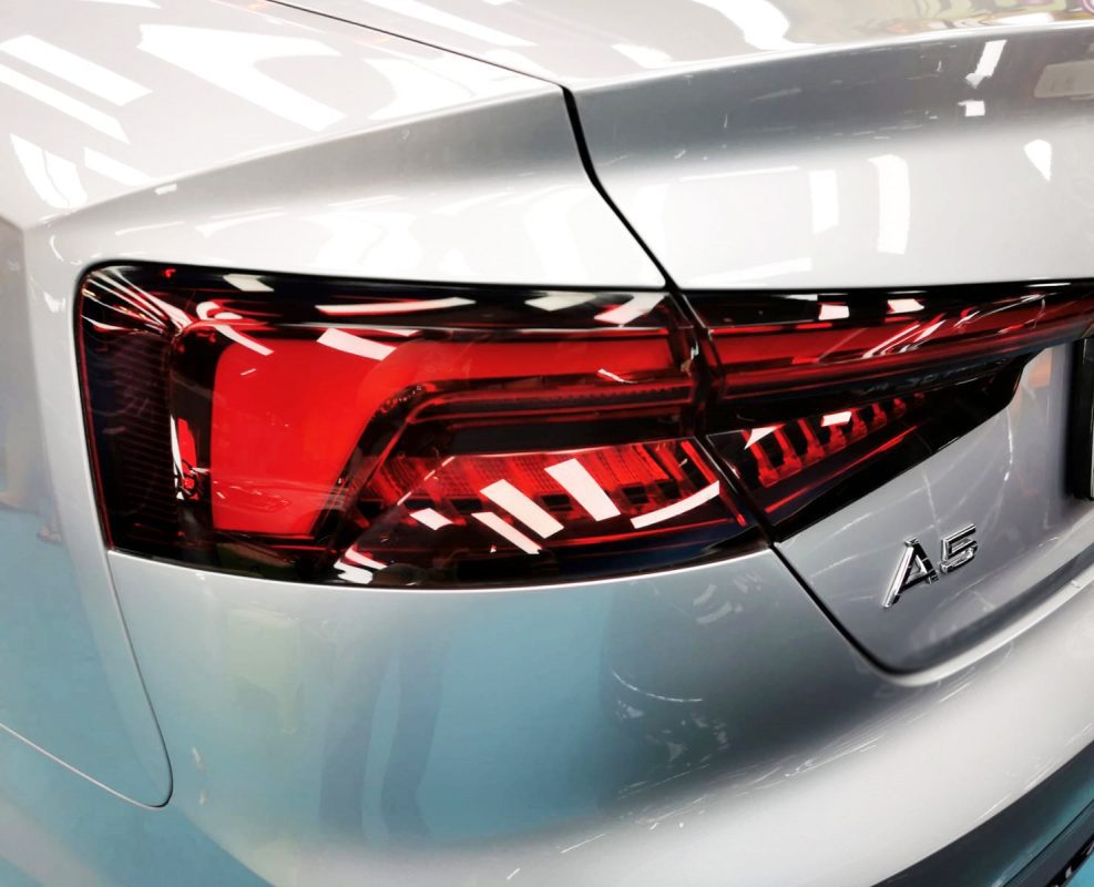 The coated bonnet of the Audi A5 Cabriolet under workshop lighting.