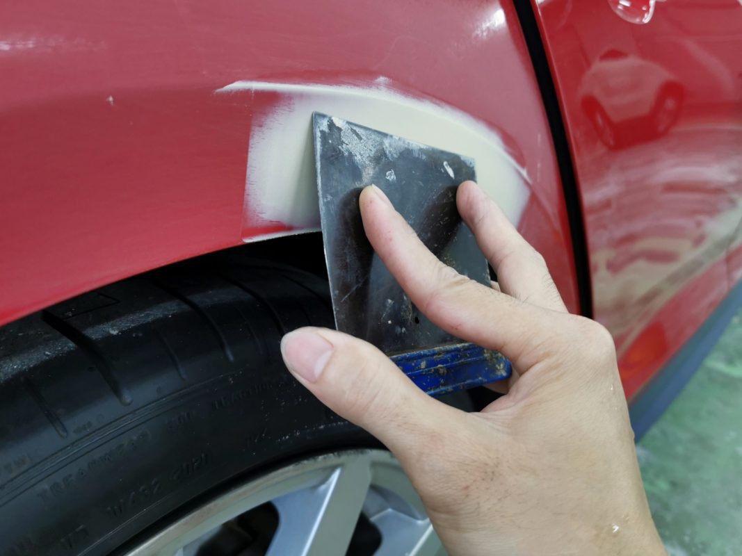 The body of the Audi A5 being examined and putty applied to imperfections.