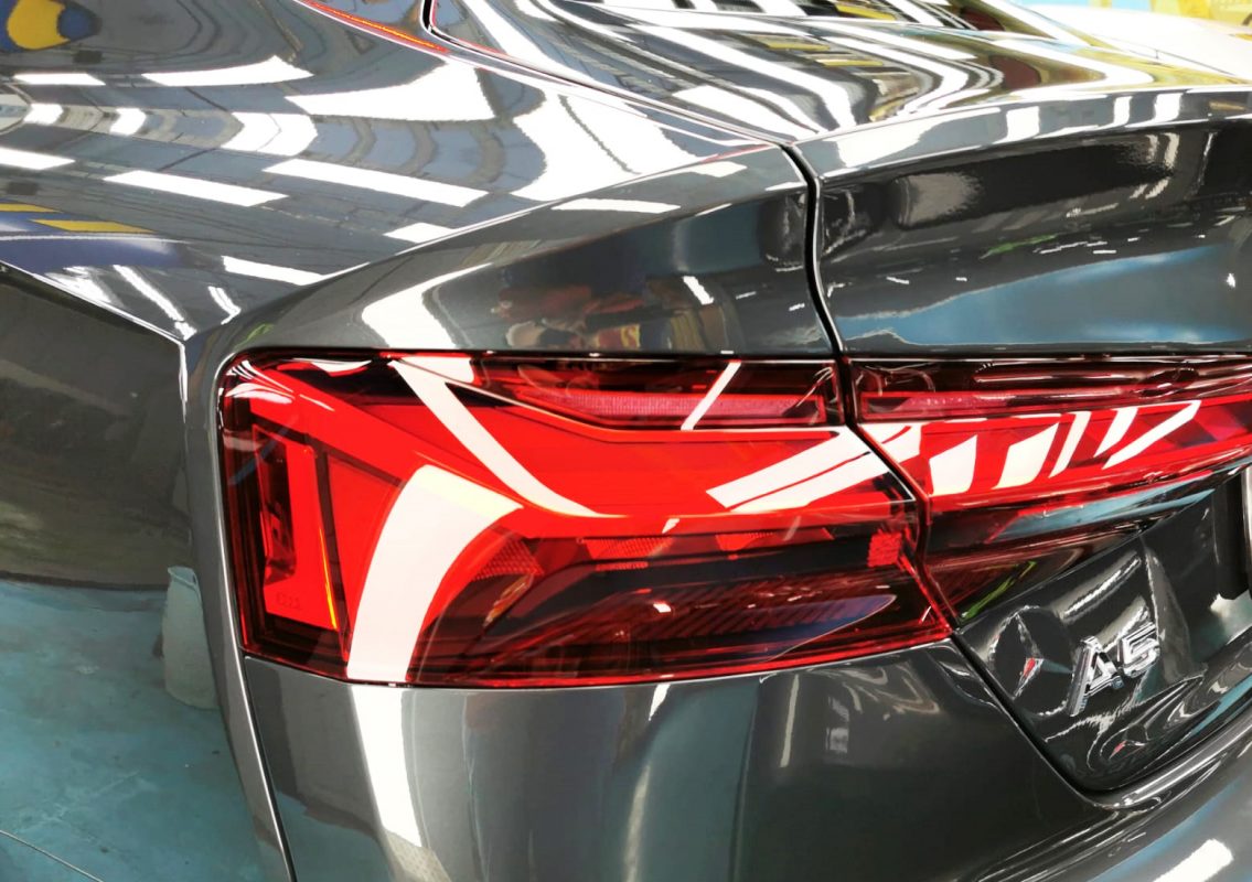 The coated bonnet of the Audi A5 under workshop lighting.