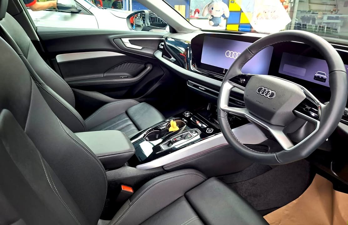 Audi A5 interior with black seats, steering wheel and digital dashboard.