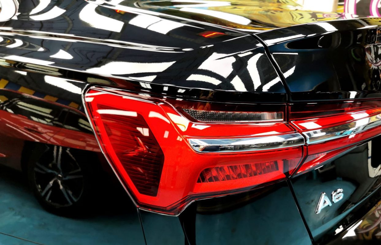 The coated bonnet of the Audi A6 under workshop lighting.